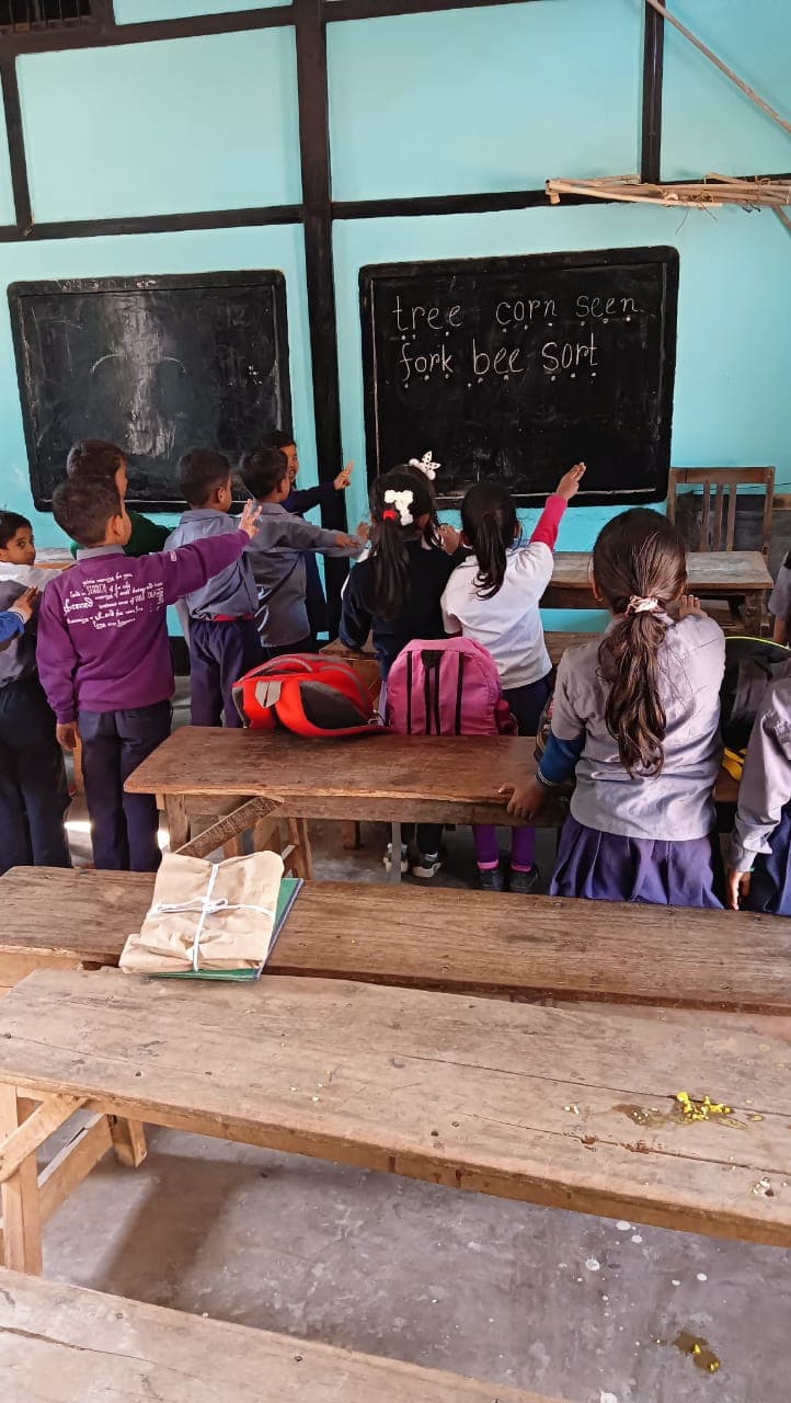 Children practising phonics blending at the blackboard